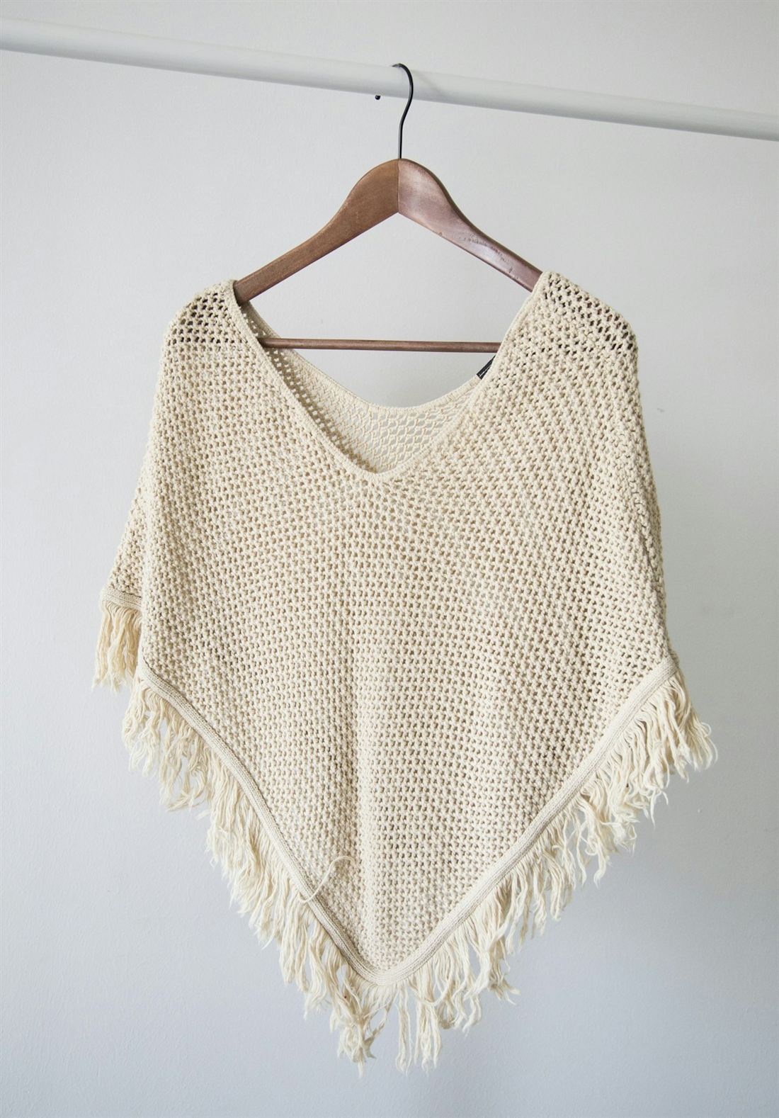 cream knit poncho illustrating sweater silhouette and fit development